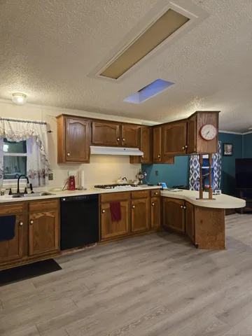 a large kitchen with stainless steel appliances granite countertop a large counter top and wooden floors