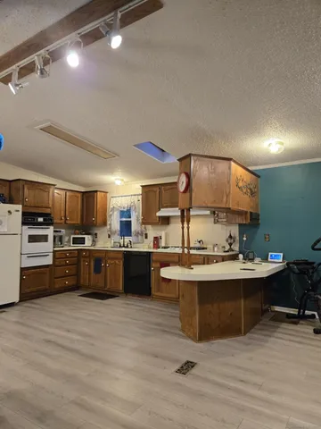 a kitchen with a sink cabinets and wooden floor