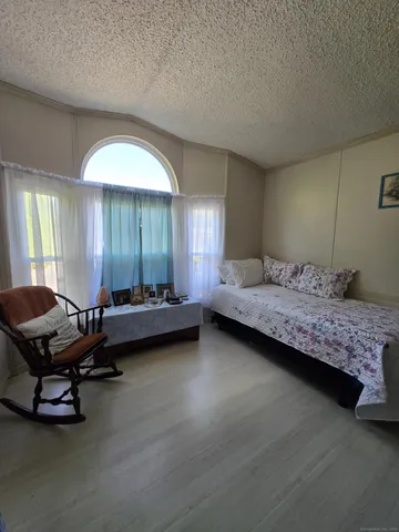 a bedroom with a bed and a lounge chair