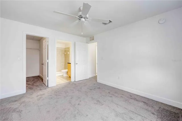 a view of staircase with white walls and white door