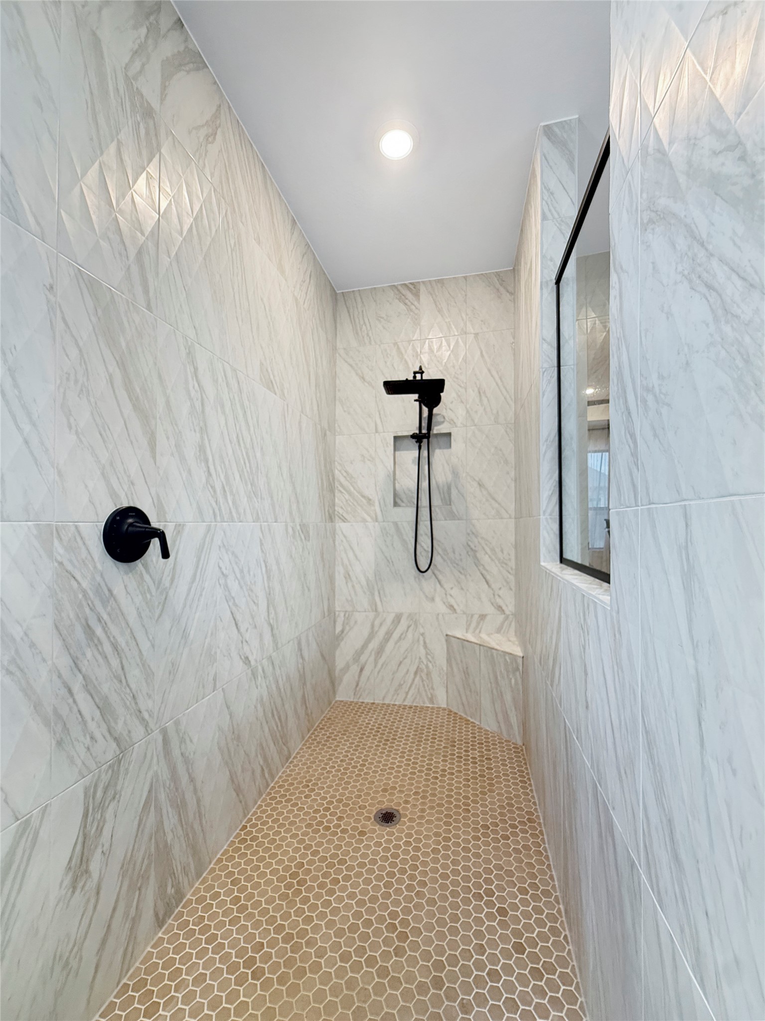 26918 Swanborough Road Spring, TX 77389 - Photo 23 of 50 The primary bath features an oversized walk-in shower clad in marble-look tile, complete with a built-in niche, bench seating, and matte-black fixtures for a spa-like retreat