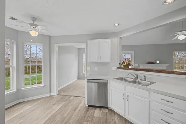 a kitchen with granite countertop white cabinets and white appliances