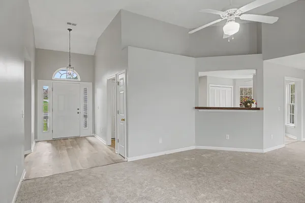 a view of a chandelier fan and livingroom with furniture