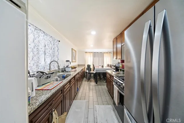 a kitchen with stainless steel appliances granite countertop lots of counter space and a refrigerator
