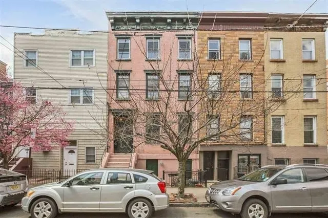 a front view of a residential apartment building with a parking space
