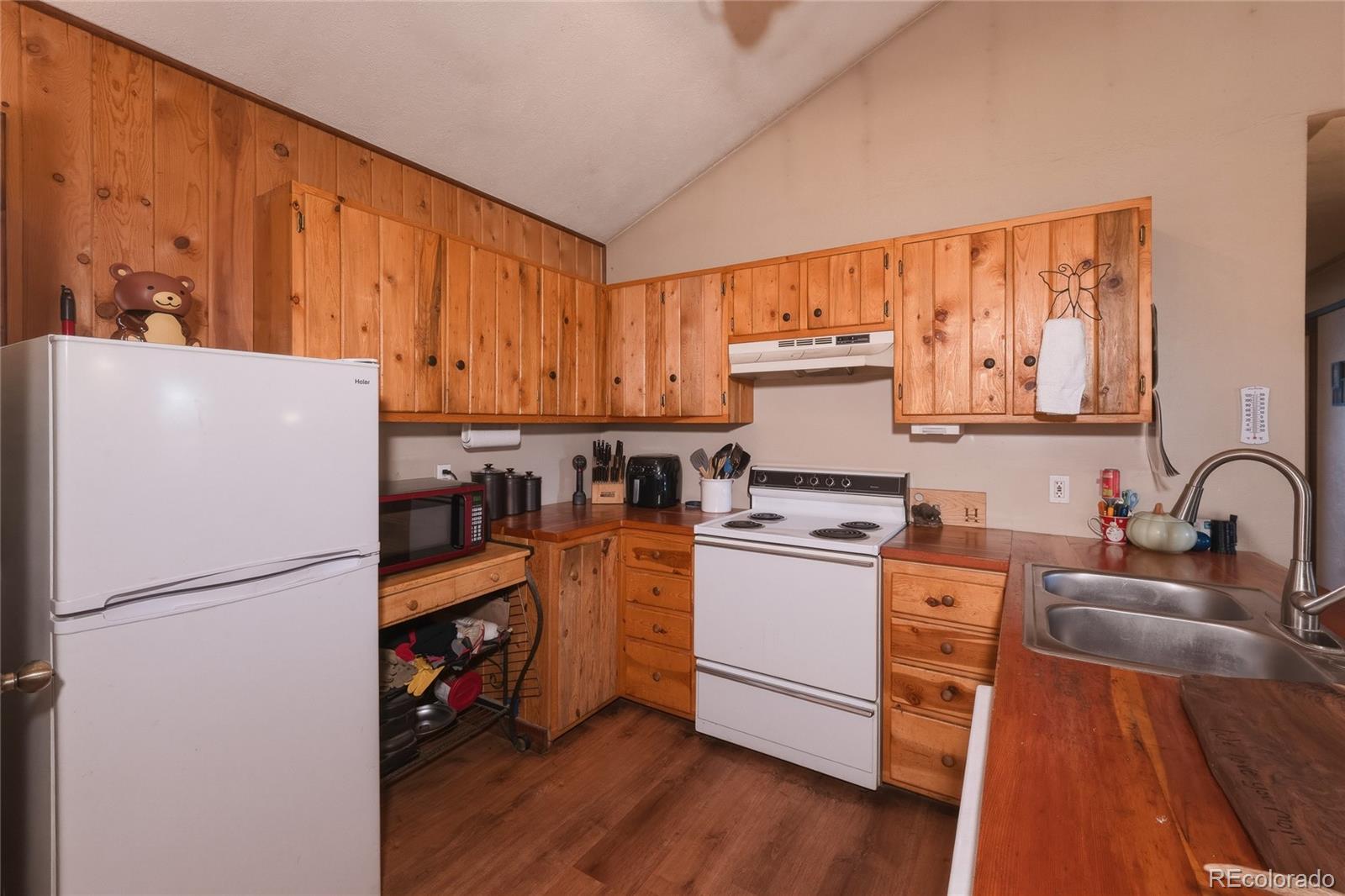 13240 Big Pine Ridge Road Weston, CO 81091 - Photo 10 of 49 a kitchen with a refrigerator a stove top oven a sink and cabinets with wooden floor