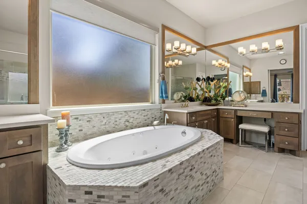 a bathroom with a granite countertop sink toilet a large mirror a bathtub and shower