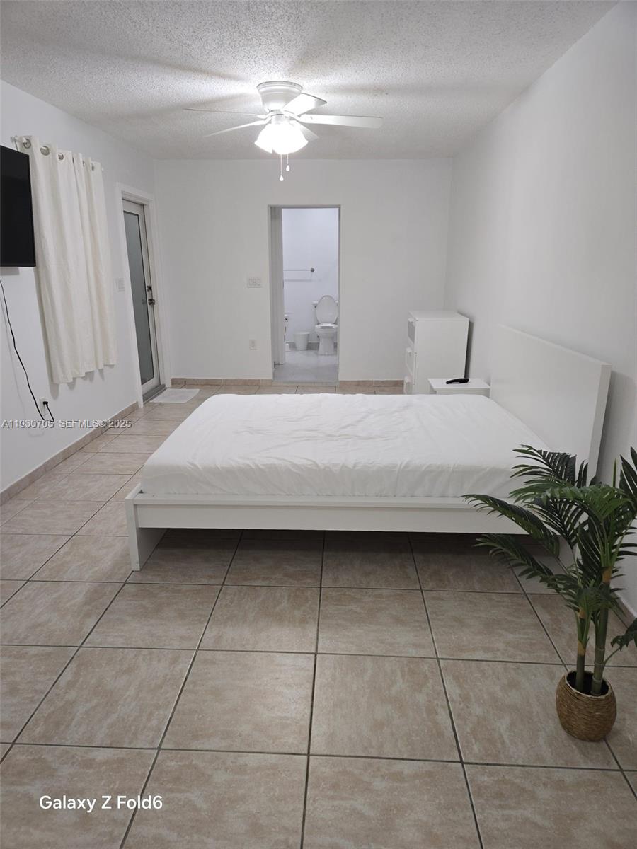 19251 Northwest 61st Avenue, Unit 19251 Hialeah, FL 33015 - Photo 3 of 10 a bedroom with a bed and a potted plant