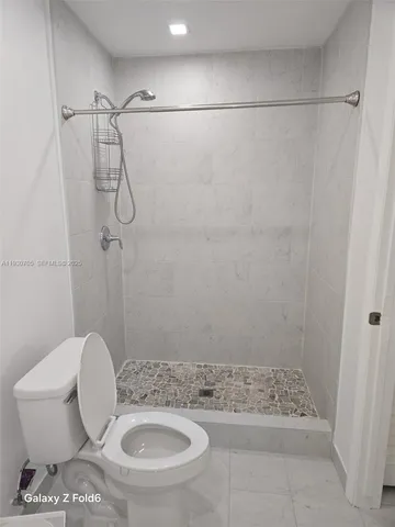 a bathroom with a toilet and a shower