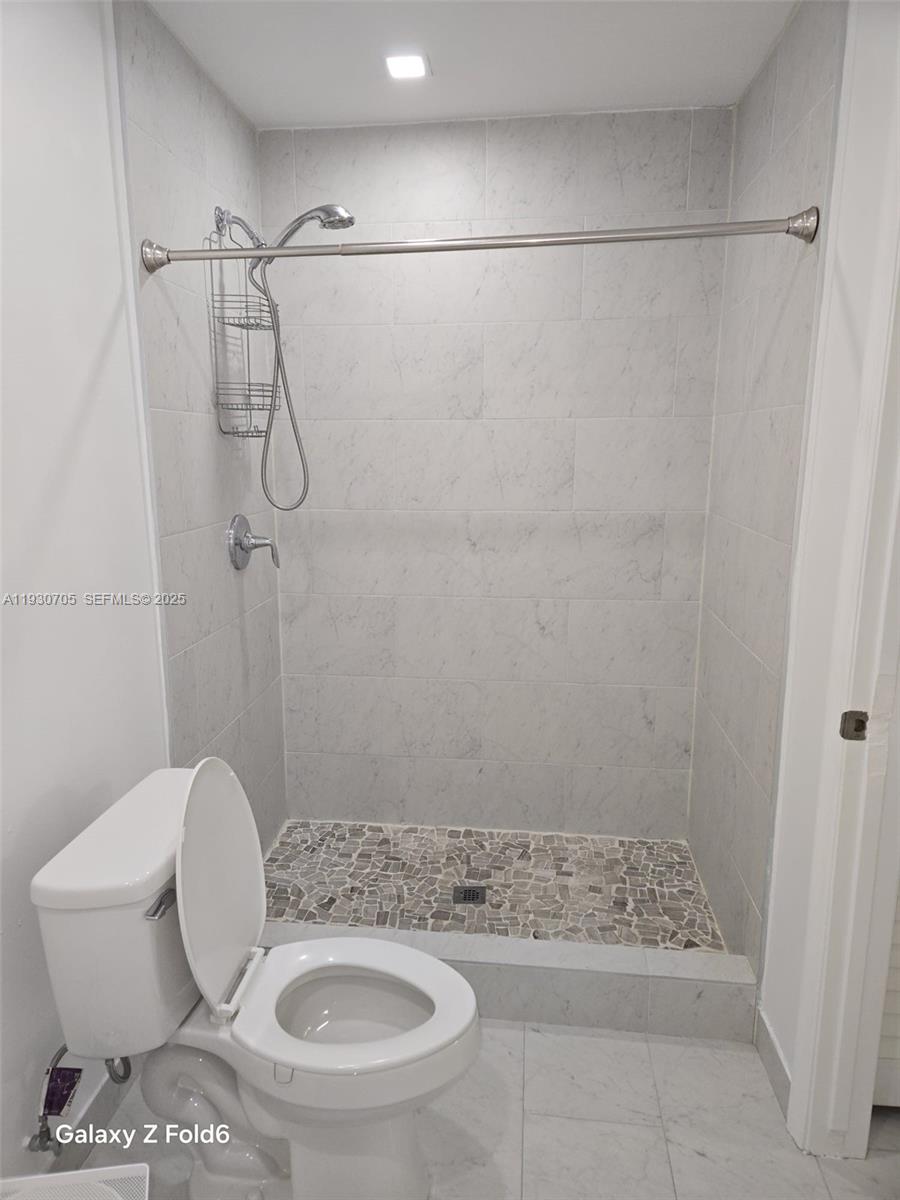 19251 Northwest 61st Avenue, Unit 19251 Hialeah, FL 33015 - Photo 4 of 10 a bathroom with a toilet and a shower
