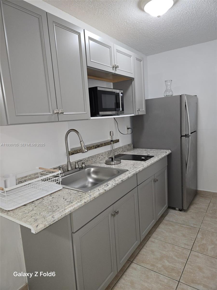 19251 Northwest 61st Avenue, Unit 19251 Hialeah, FL 33015 - Photo 7 of 10 a kitchen with stainless steel appliances granite countertop a sink stove and refrigerator