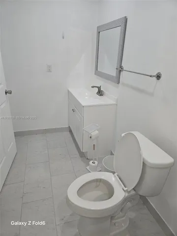 a bathroom with a sink toilet and mirror