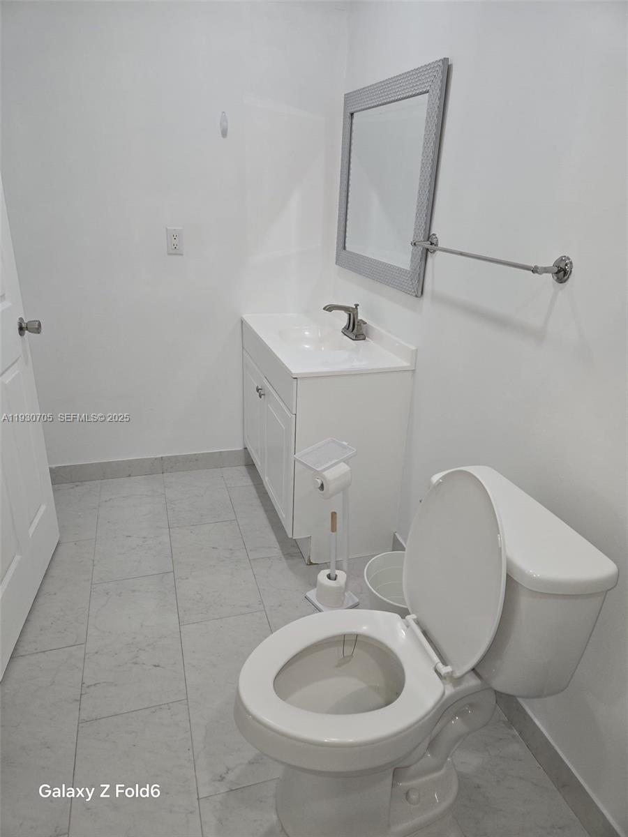 19251 Northwest 61st Avenue, Unit 19251 Hialeah, FL 33015 - Photo 8 of 10 a bathroom with a sink toilet and mirror