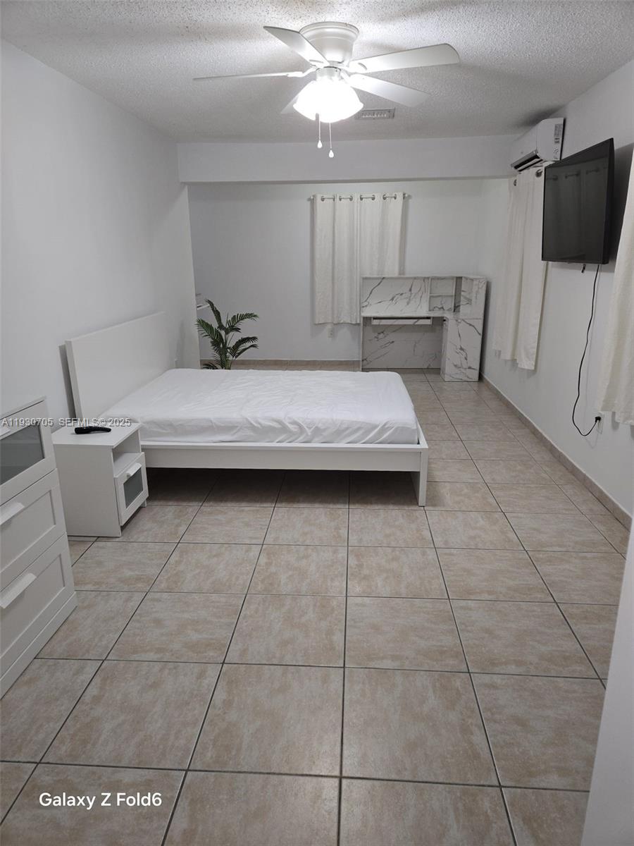 19251 Northwest 61st Avenue, Unit 19251 Hialeah, FL 33015 - Photo 9 of 10 a living room with a couch and a flat screen tv