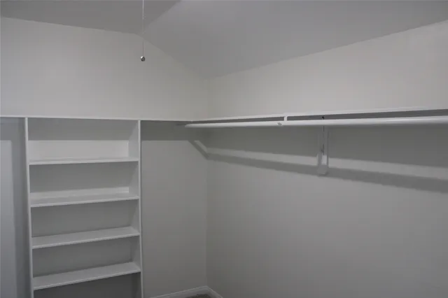 a view of walk in closet with empty racks
