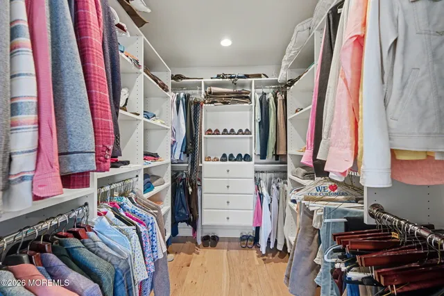 a view of walk in closet with clothes and shoes