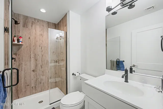 a bathroom with a sink a toilet and shower