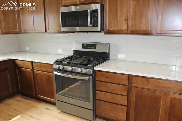 a kitchen with a sink a stove and cabinets