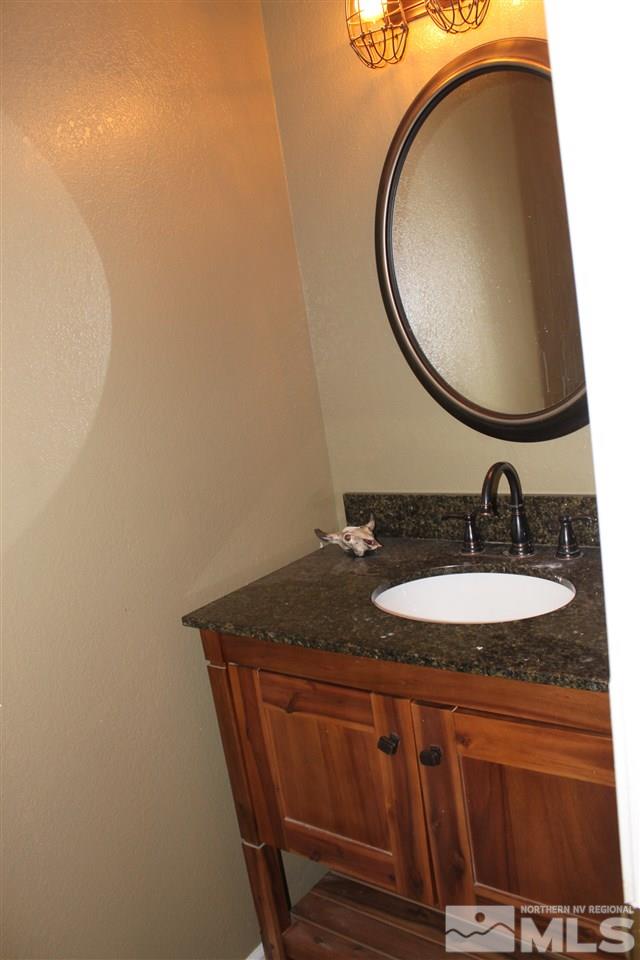 2000 Piute Creek Road Reno, NV 89510 - Photo 13 of 17 a bathroom with a granite countertop sink and a mirror