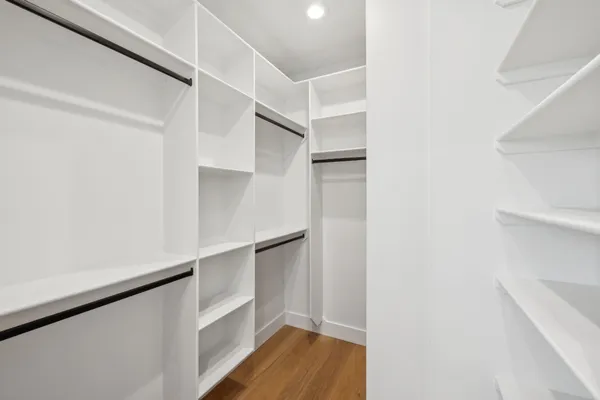a view of walk in closet with empty racks