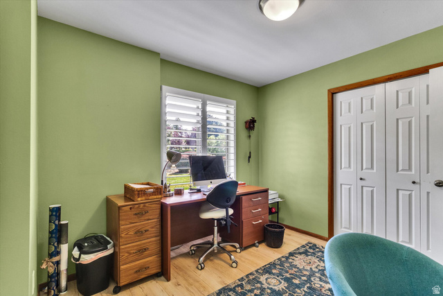 2863 Fallentine Road Sandy, UT 84093 - Photo 25 of 48 Room featuring light green walls, wood-finish flooring, a window with white plantation shutters, and a bi-fold closet with white panel doors