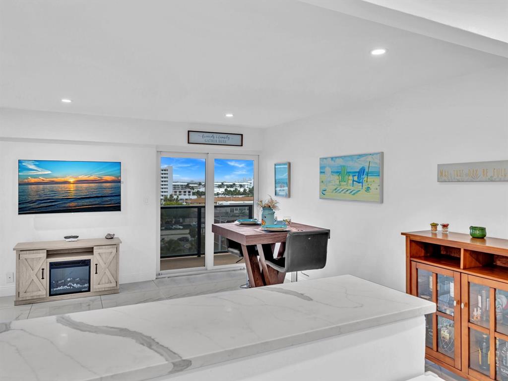 5100 Dupont Boulevard, Unit 8G Fort Lauderdale, FL 33308 - Photo 17 of 65 a living room with furniture a flat screen tv and a fireplace