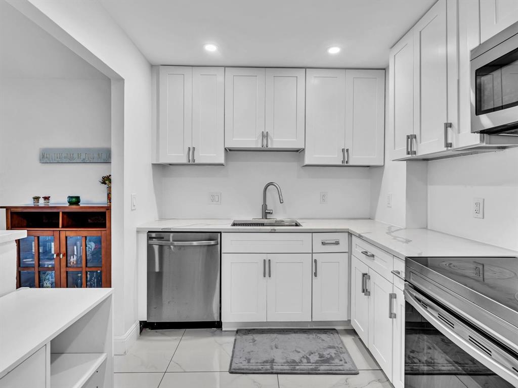 5100 Dupont Boulevard, Unit 8G Fort Lauderdale, FL 33308 - Photo 18 of 65 a kitchen with stainless steel appliances granite countertop a sink and dishwasher a stove top oven with white cabinets