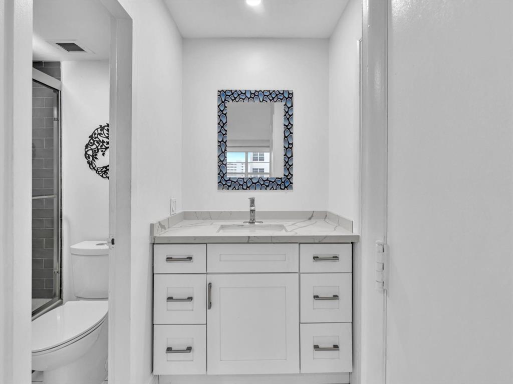 5100 Dupont Boulevard, Unit 8G Fort Lauderdale, FL 33308 - Photo 25 of 65 a bathroom with a granite countertop toilet sink and mirror