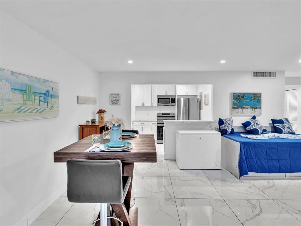 5100 Dupont Boulevard, Unit 8G Fort Lauderdale, FL 33308 - Photo 35 of 65 a kitchen with kitchen island a stove a table and chairs in it