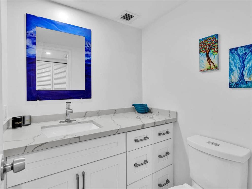 5100 Dupont Boulevard, Unit 8G Fort Lauderdale, FL 33308 - Photo 36 of 65 a bathroom with a toilet sink vanity and mirror