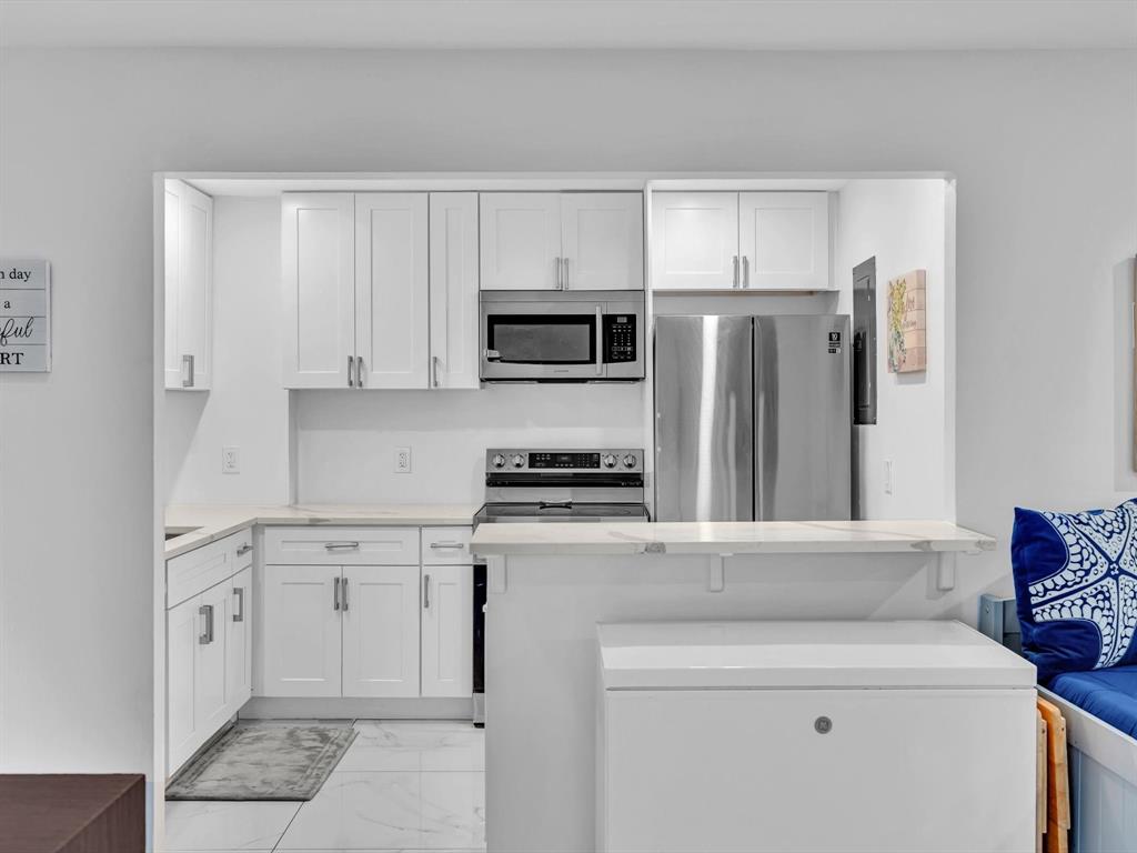 5100 Dupont Boulevard, Unit 8G Fort Lauderdale, FL 33308 - Photo 10 of 65 a kitchen with white cabinets and stainless steel appliances