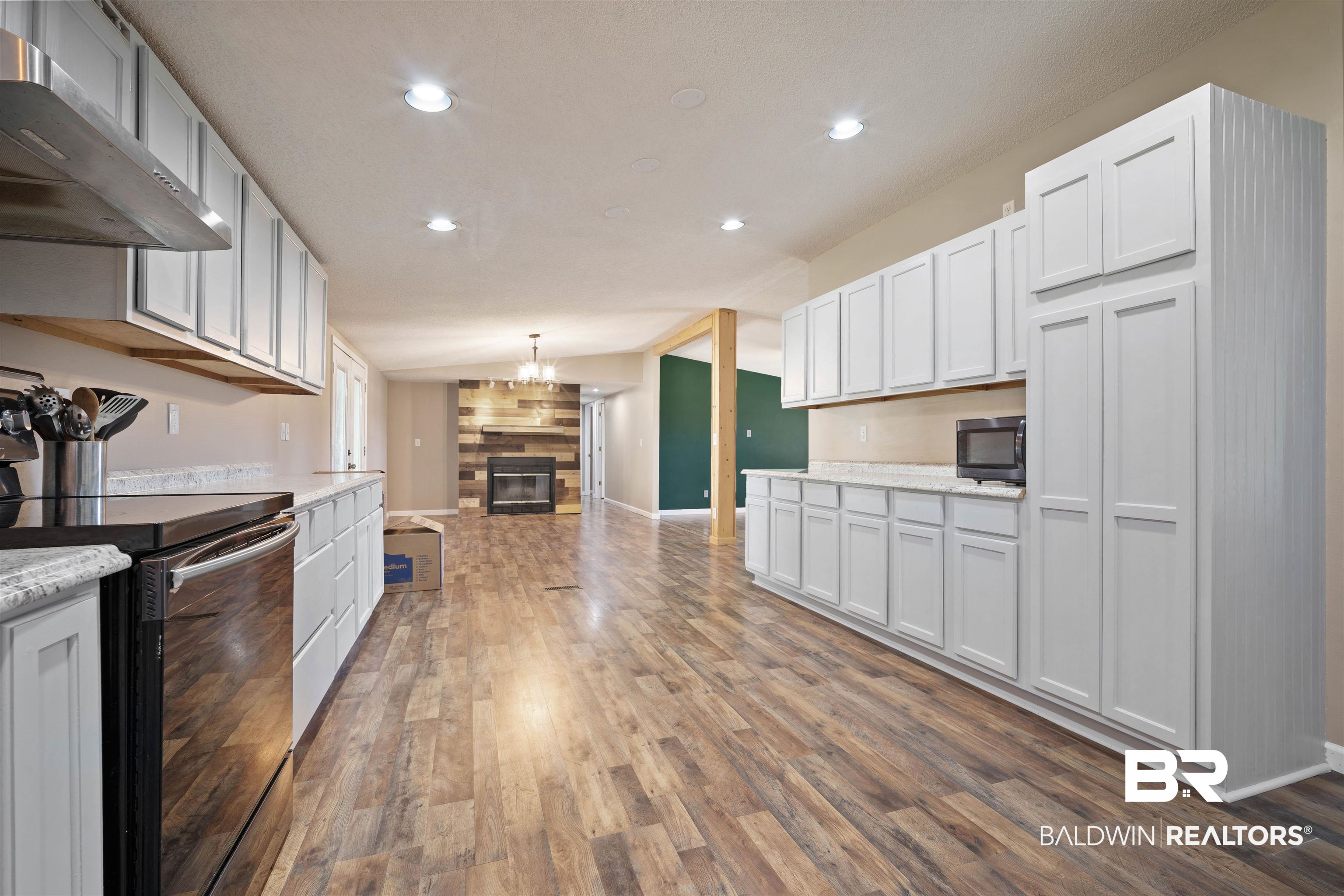 9011 Wilmer Georgetown Road Wilmer, AL 36587 - Photo 12 of 34 Kitchen with recessed lighting, exhaust hood, a large fireplace, black appliances, and wood finished floors