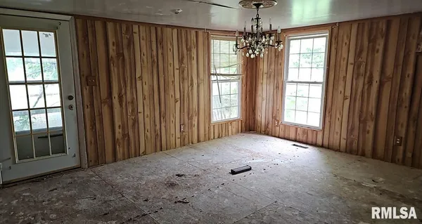 a view of a spacious bedroom with windows and chandelier