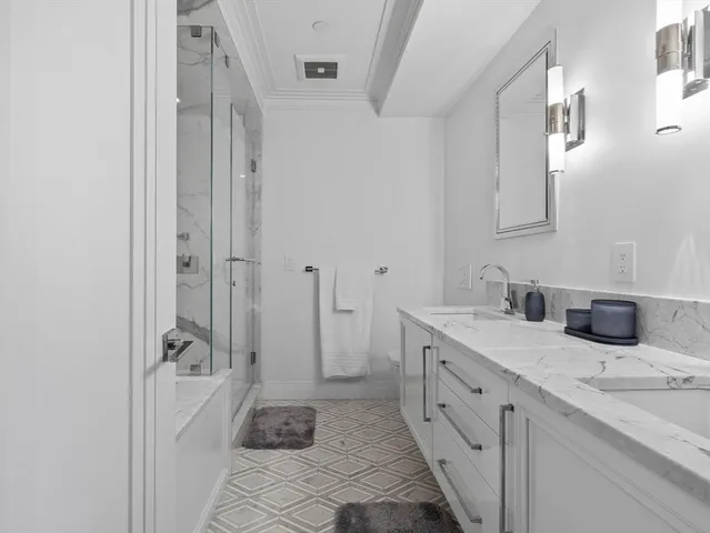 a spacious bathroom with a granite countertop sink a mirror and a shower