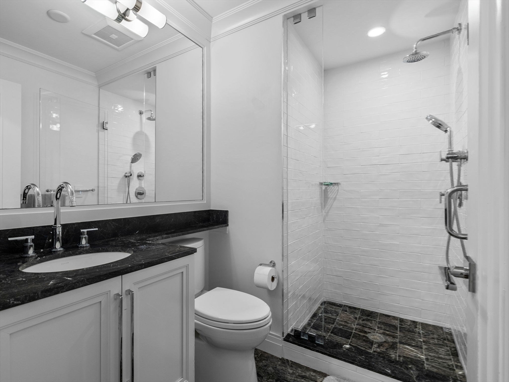 5 Joy Street, Unit 1 Boston, MA 02108 - Photo 27 of 32 a bathroom with a granite countertop sink a toilet and a mirror