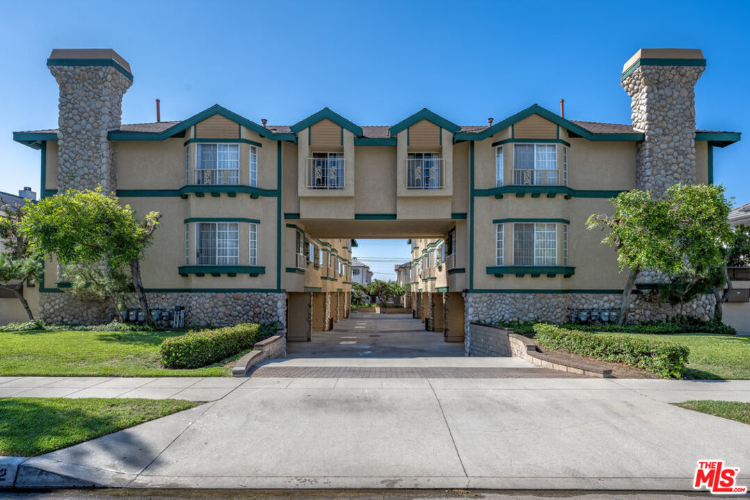 a front view of a house with a yard and potted plants