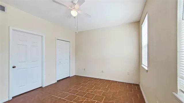an empty room with a ceiling fan and a window