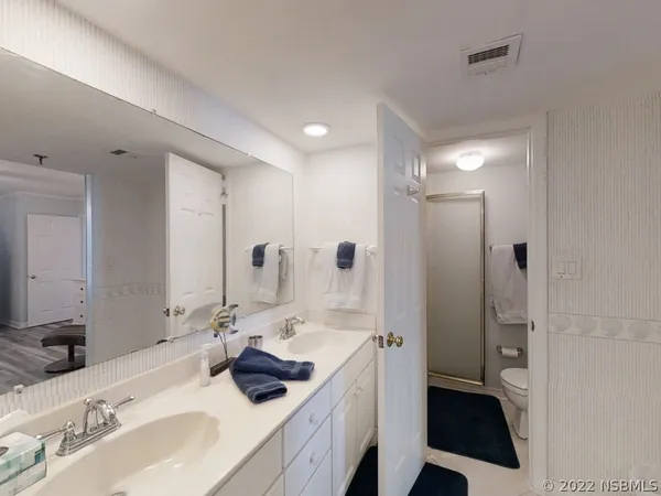 a spacious bedroom with a bed and a chandelier