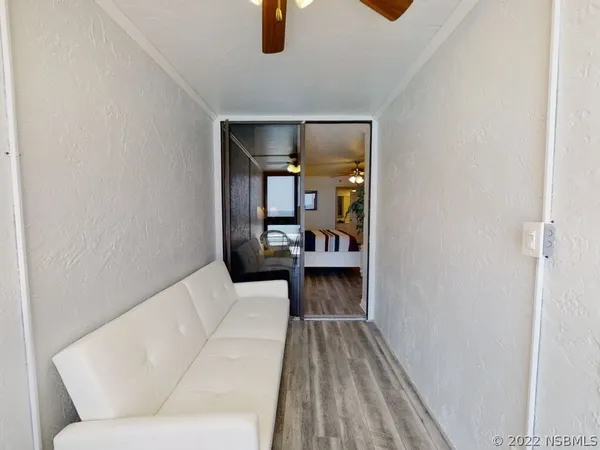 a living room with furniture kitchen view and a large window