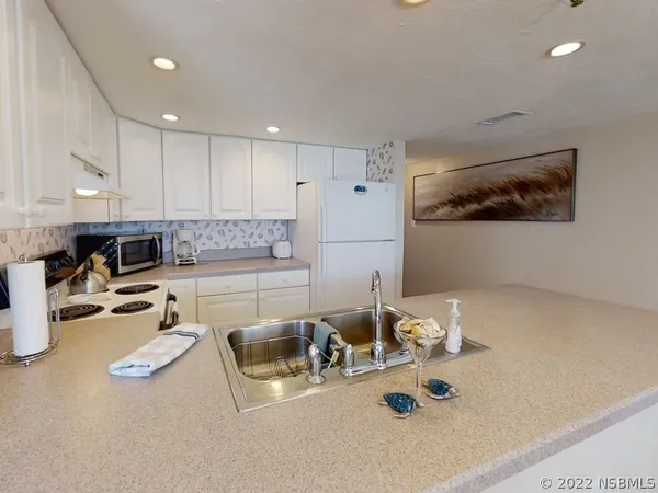 a large kitchen with a table and chairs