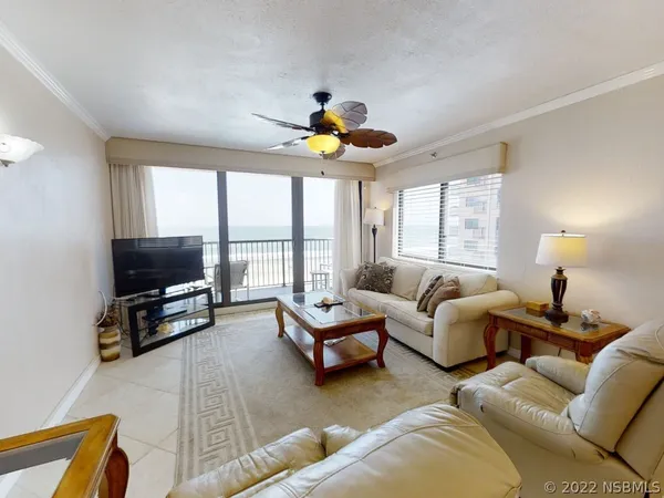 a living room with furniture kitchen view and a chandelier