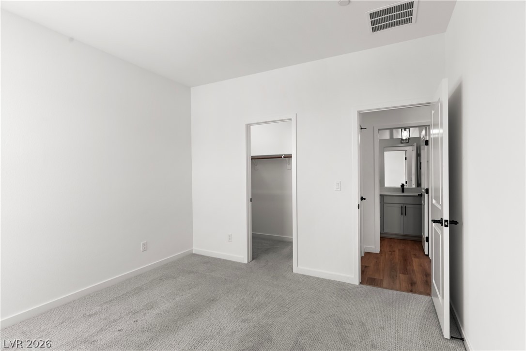 633 Infinity Rdg Street Las Vegas, NV 89138 - Photo 18 of 30 Unfurnished bedroom with a walk in closet and light colored carpet