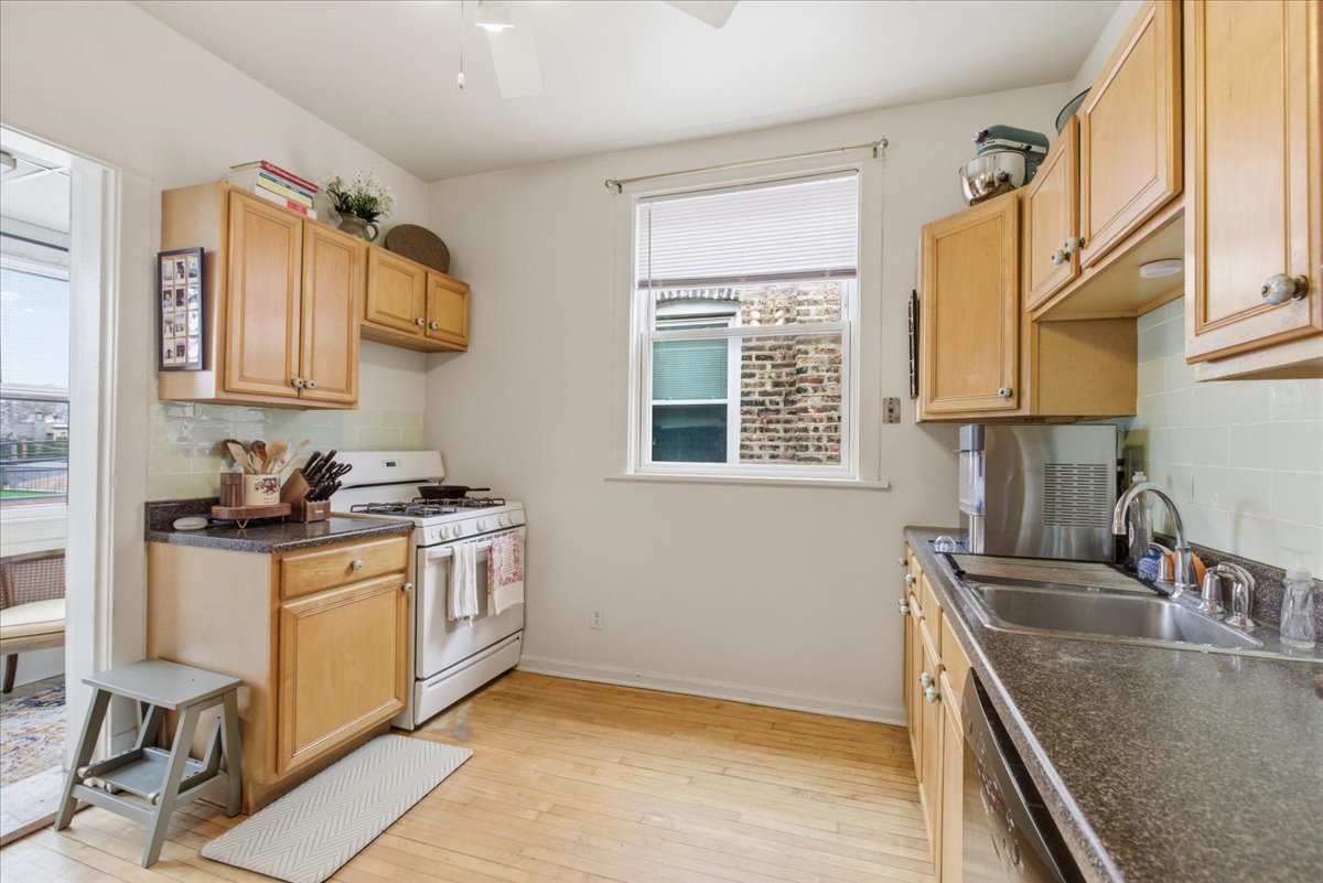 2318 West Addison Street Chicago, IL 60618 - Photo 12 of 31 a kitchen with stainless steel appliances granite countertop a sink stove and refrigerator