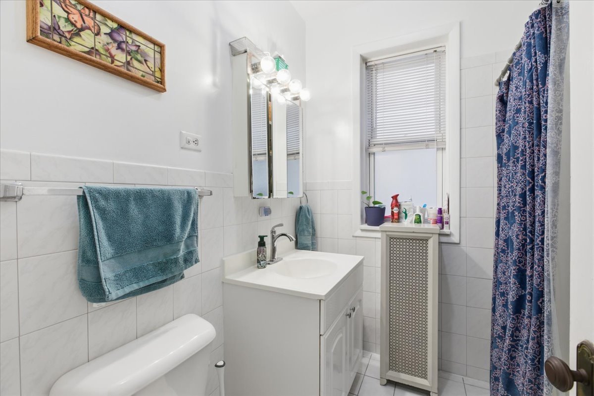 2318 West Addison Street Chicago, IL 60618 - Photo 22 of 31 a bathroom with a sink vanity mirror and toilet