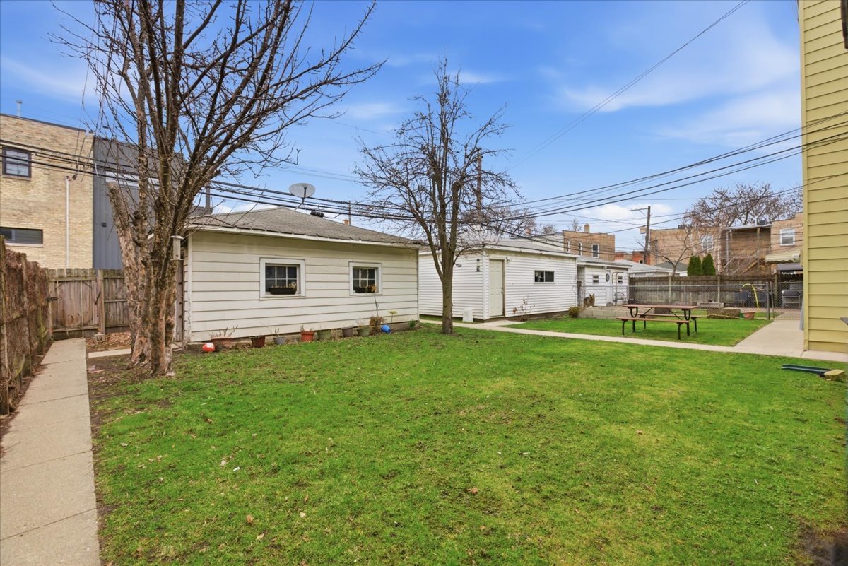 2318 West Addison Street Chicago, IL 60618 - Photo 27 of 31 a view of a white house next to a yard with big trees