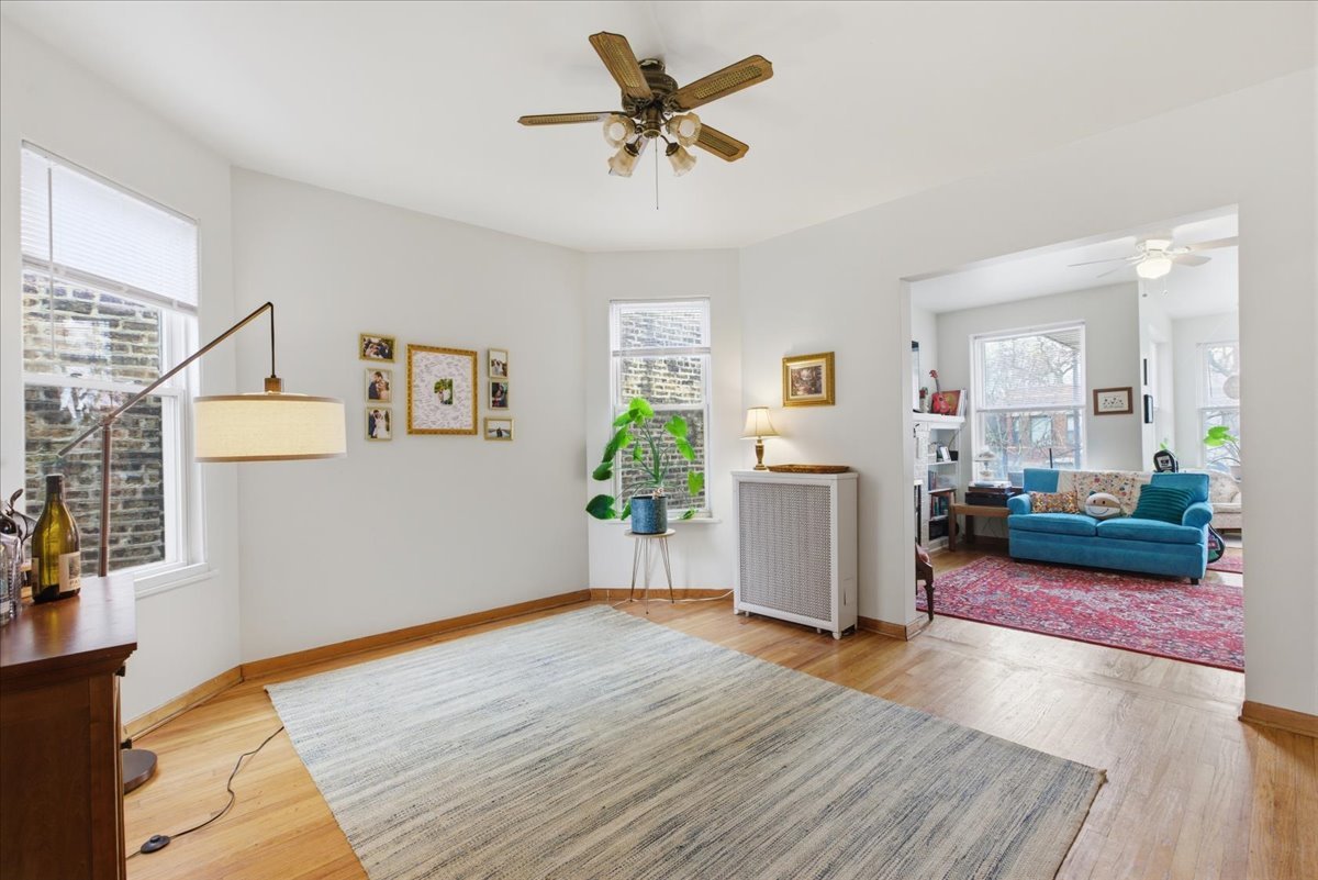 2318 West Addison Street Chicago, IL 60618 - Photo 5 of 31 a view of a livingroom with wooden floor and a ceiling fan