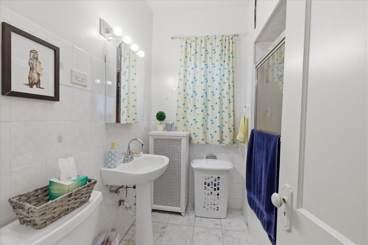 2318 West Addison Street Chicago, IL 60618 - Photo 9 of 31 a bathroom with a sink and a mirror