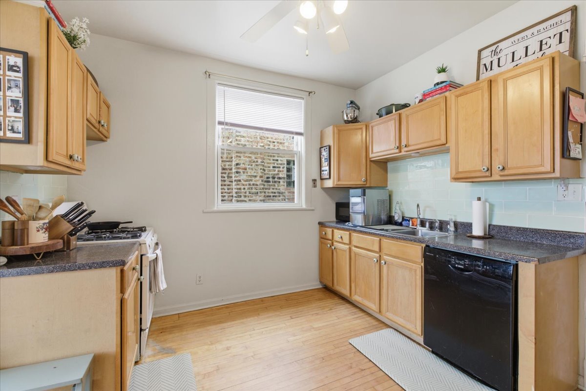 2318 West Addison Street Chicago, IL 60618 - Photo 10 of 31 a kitchen with stainless steel appliances granite countertop a sink stove and cabinets