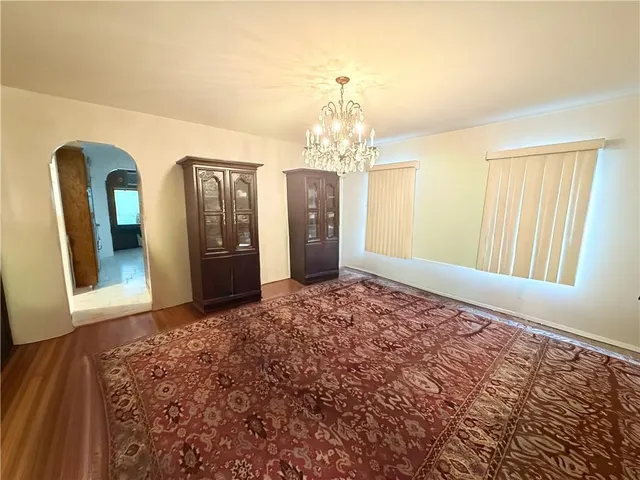 a view of a hallway with wooden floor and chandelier