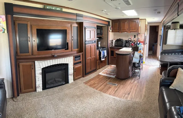 a living room with furniture a flat screen tv and a fireplace